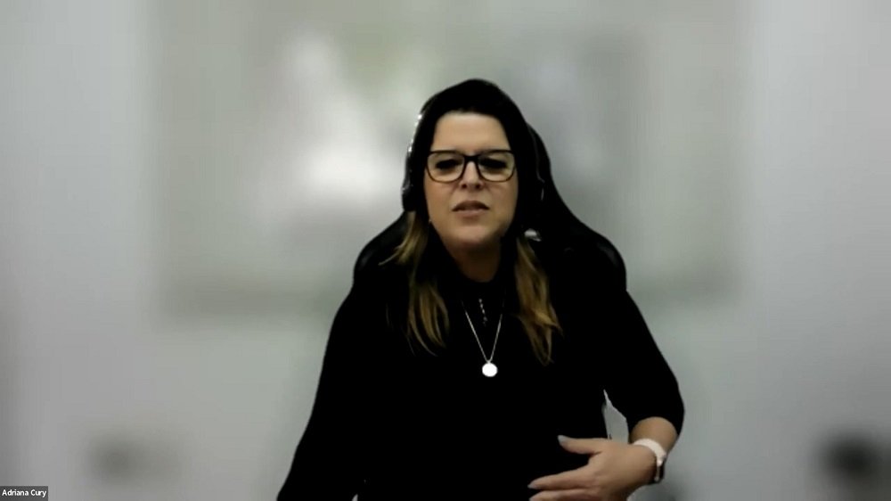 Mulher em fundo acinzentado de blusa preta, óculos, morena. Adriana Cury, diretora geral da Pais&Filhos