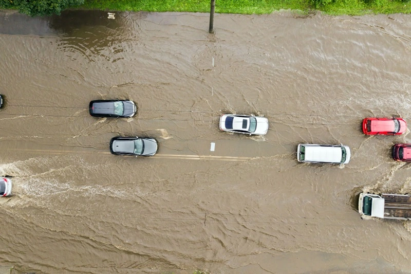 Enchente carros passam em rua coberta por água em foto retirada por drone do alto