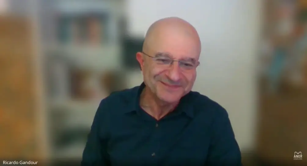 Ricardo Gandour homem branco calvo usa óculos de armação de metal blusa escura e fala sobre IA e jornalismo no Café com Aner